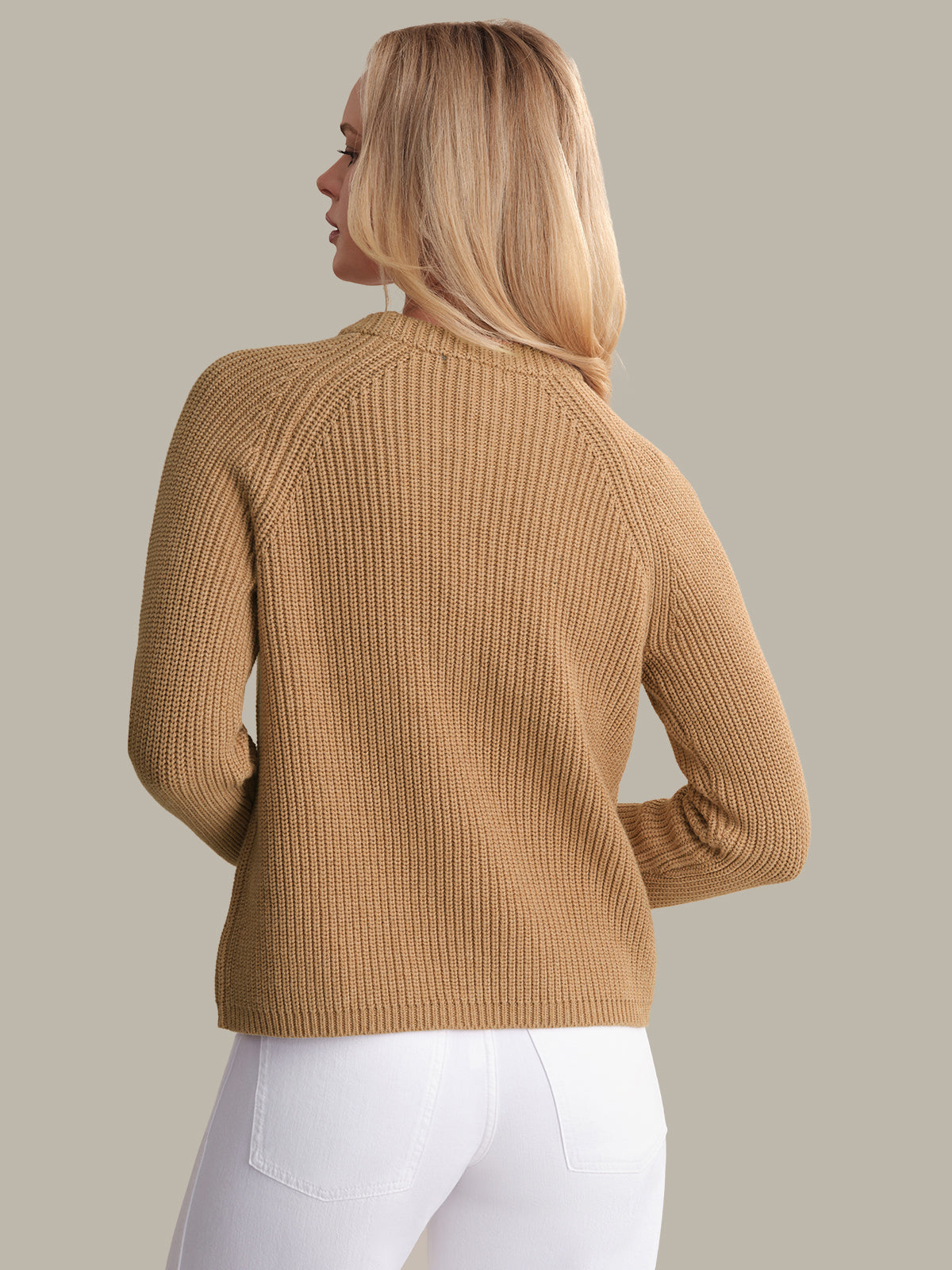 Woman wearing a brown ribbed sweater against a beige background