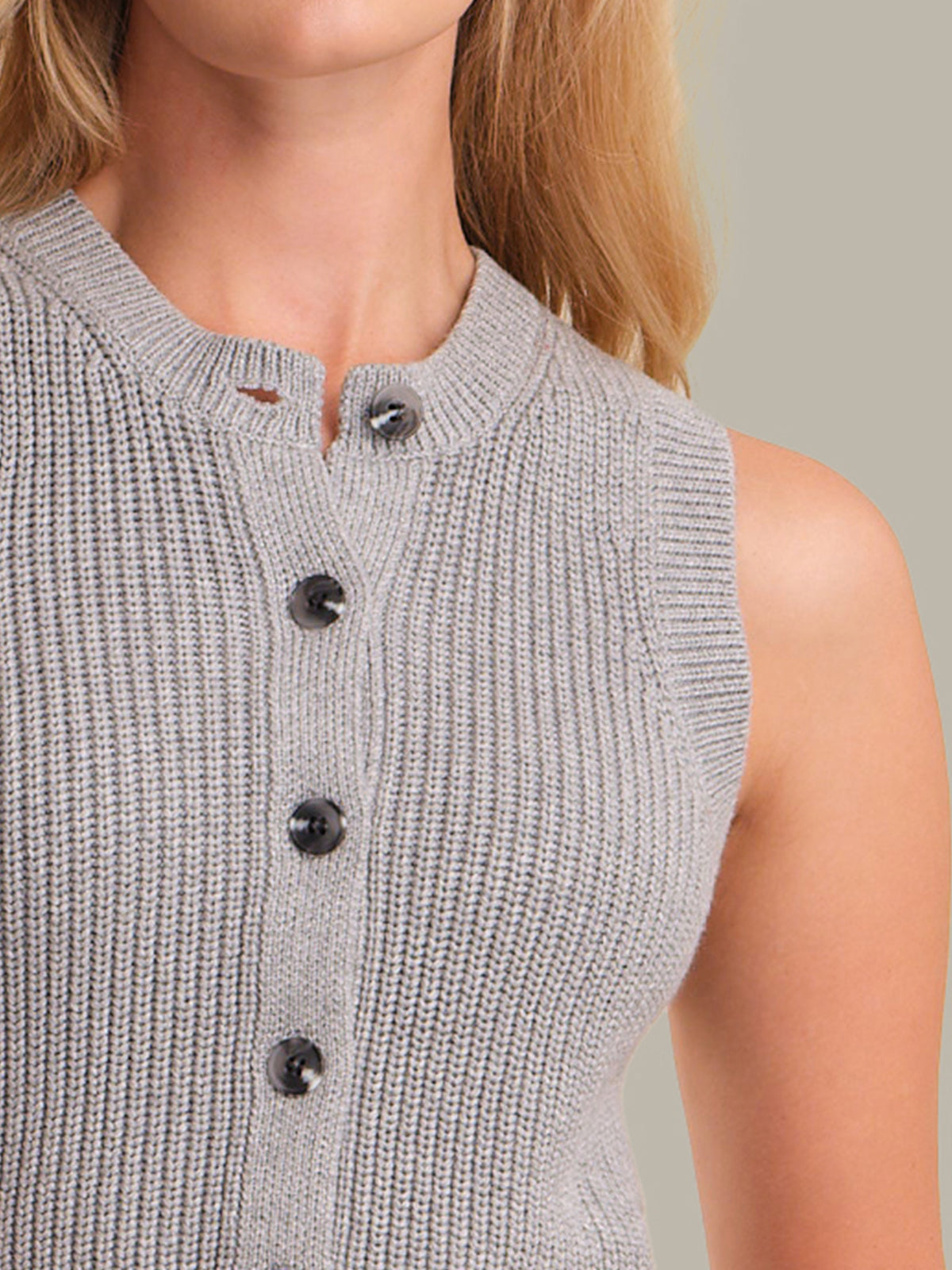Gray knitted vest with black buttons on a neutral background