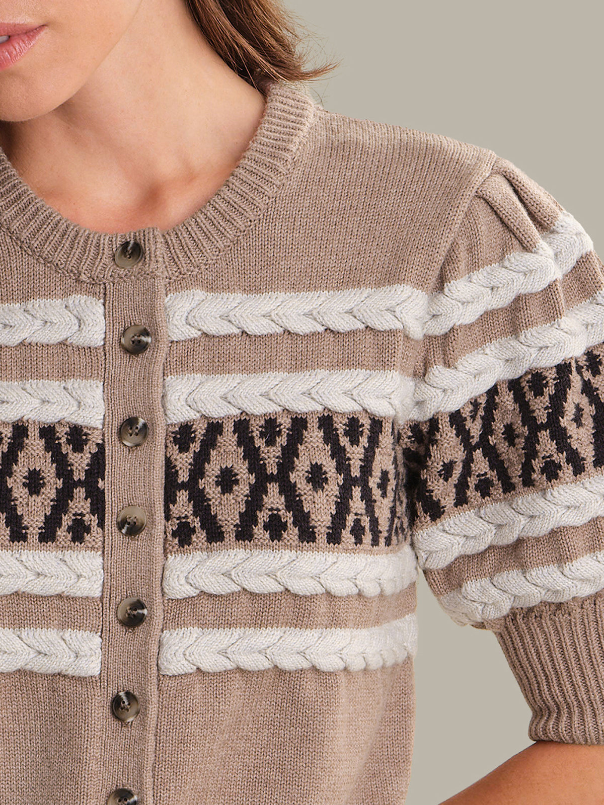 Close-up of a brown cardigan with patterned details and buttons.