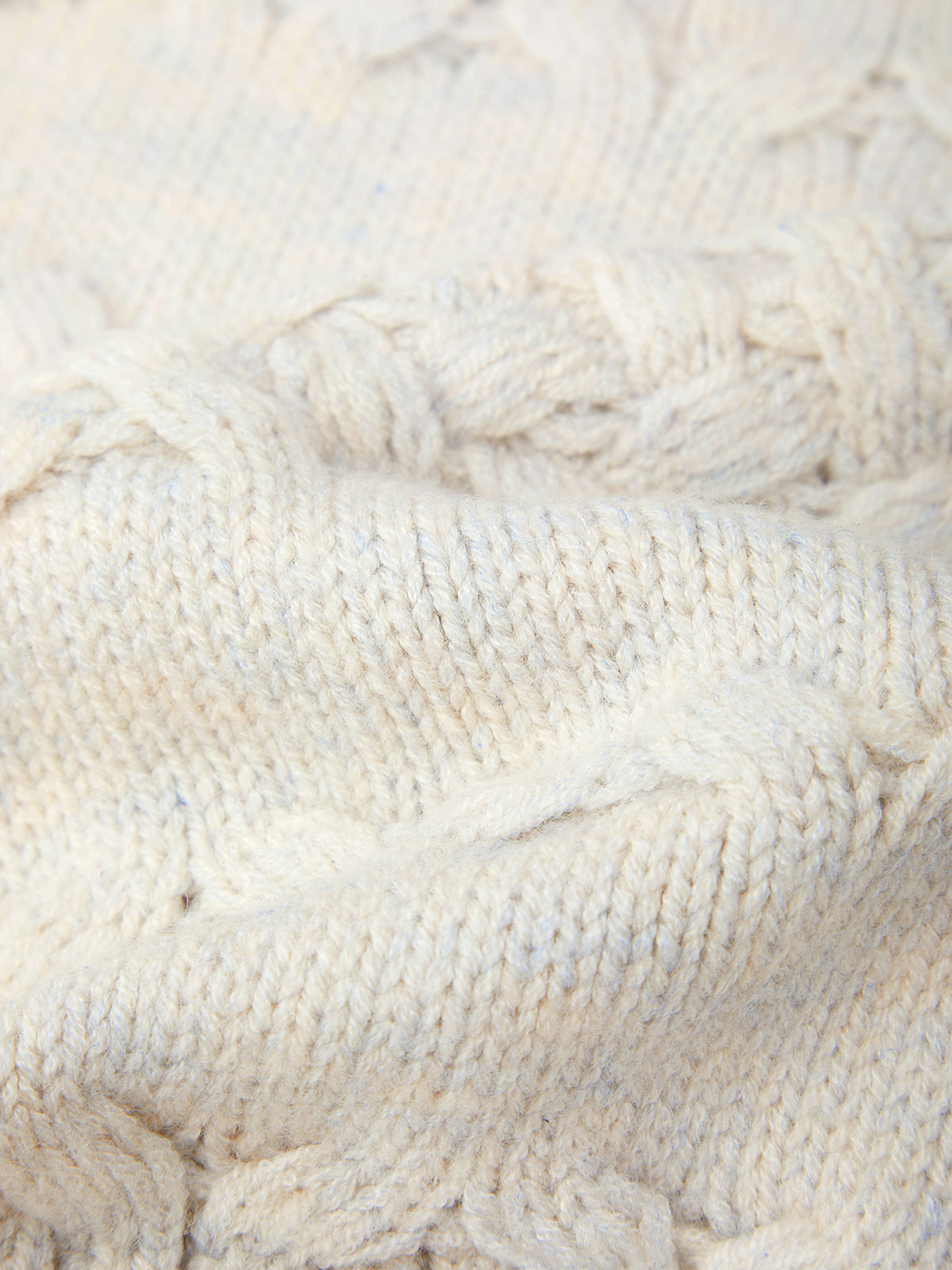 Close-up of a textured white fabric with cable knit pattern
