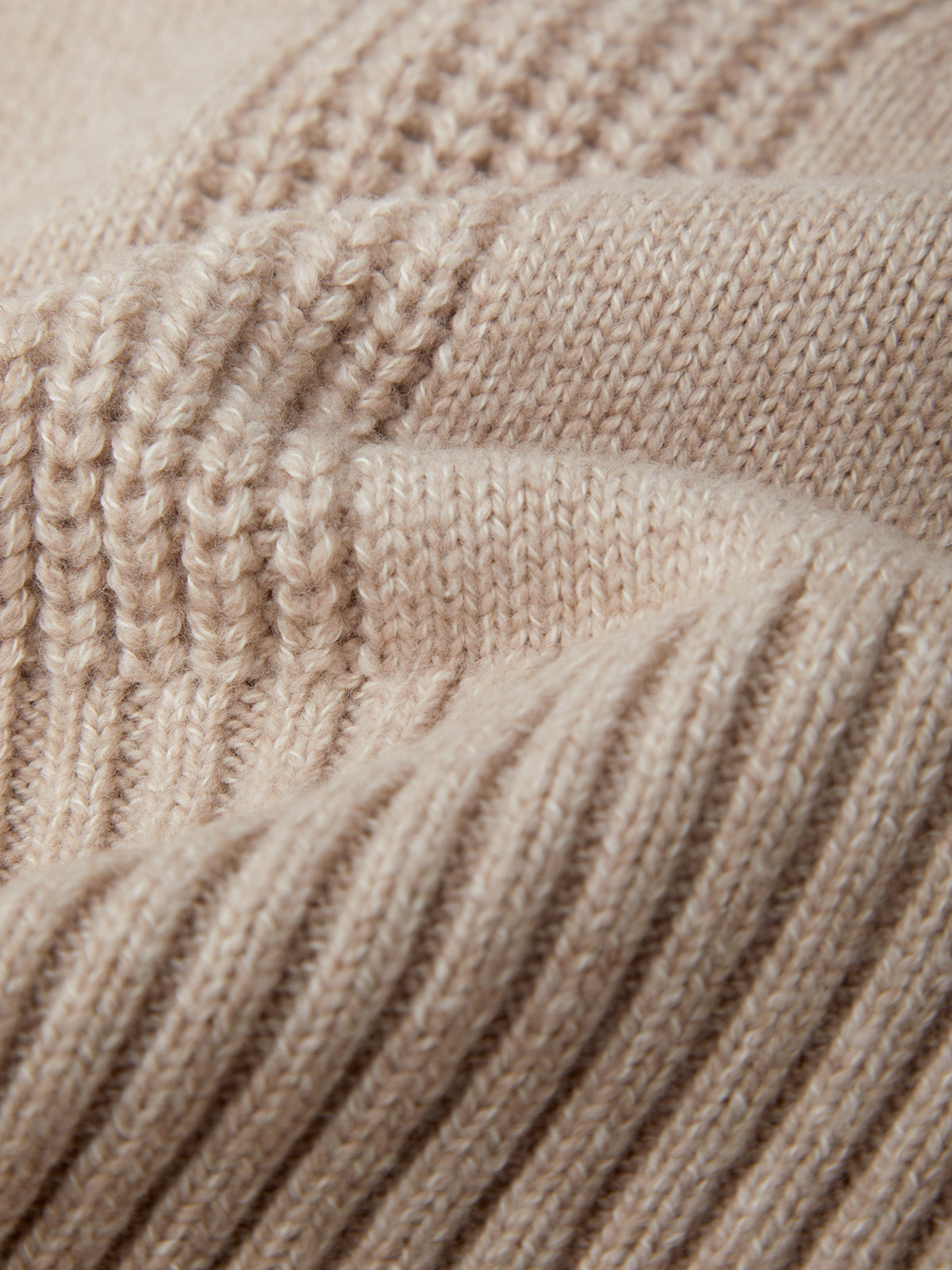 Close-up of beige knitted yarn with a textured pattern