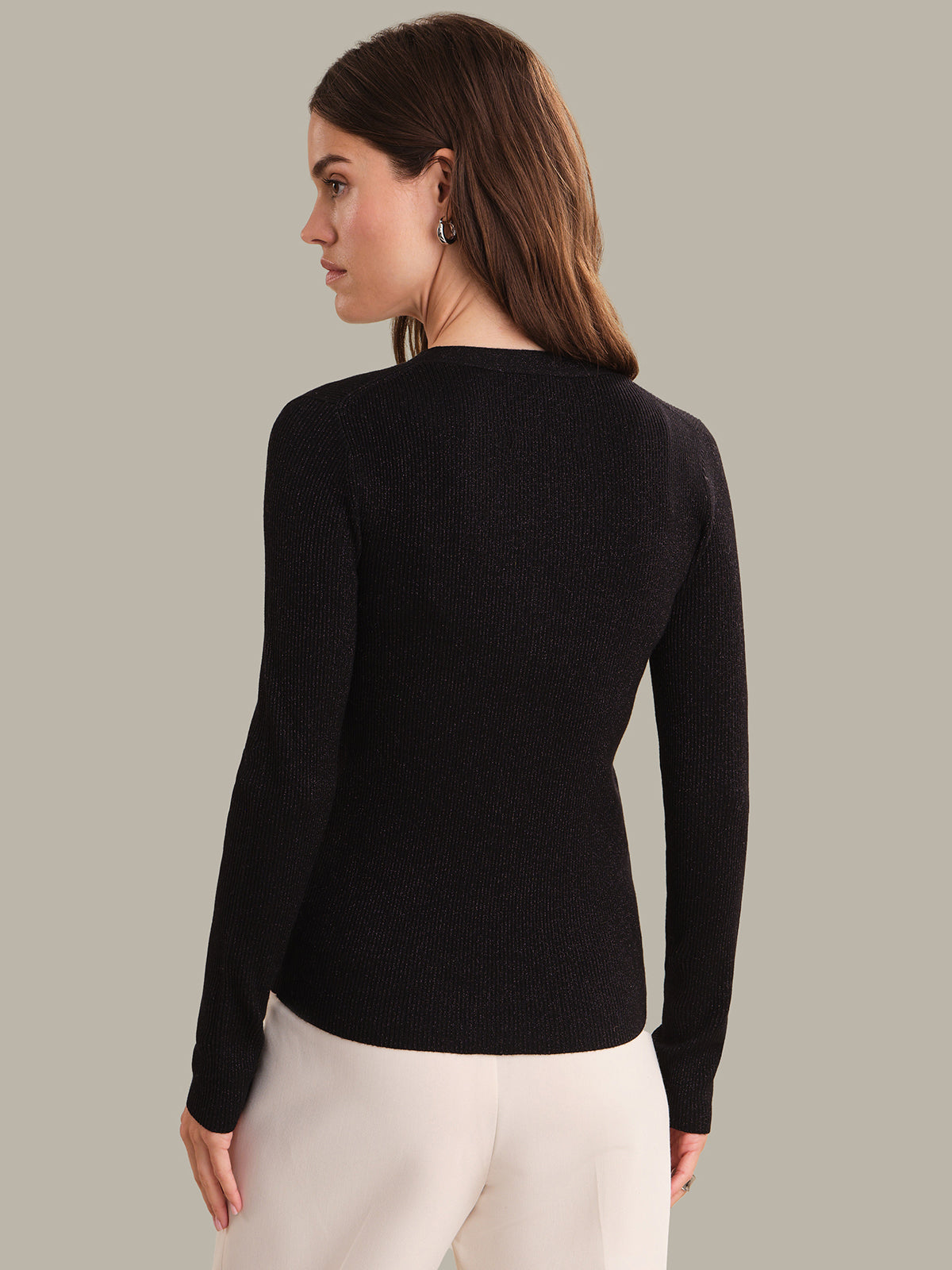 Woman wearing a black sweater against a neutral background