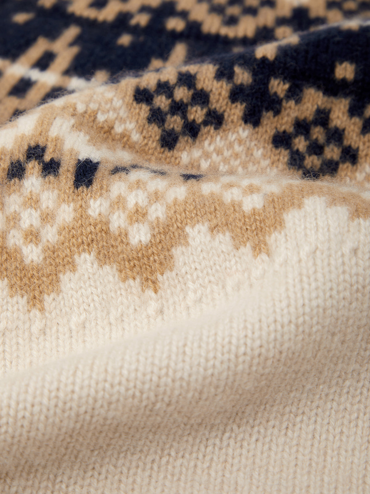 Close-up of a textured fabric with a pattern of beige, brown, and navy blue.