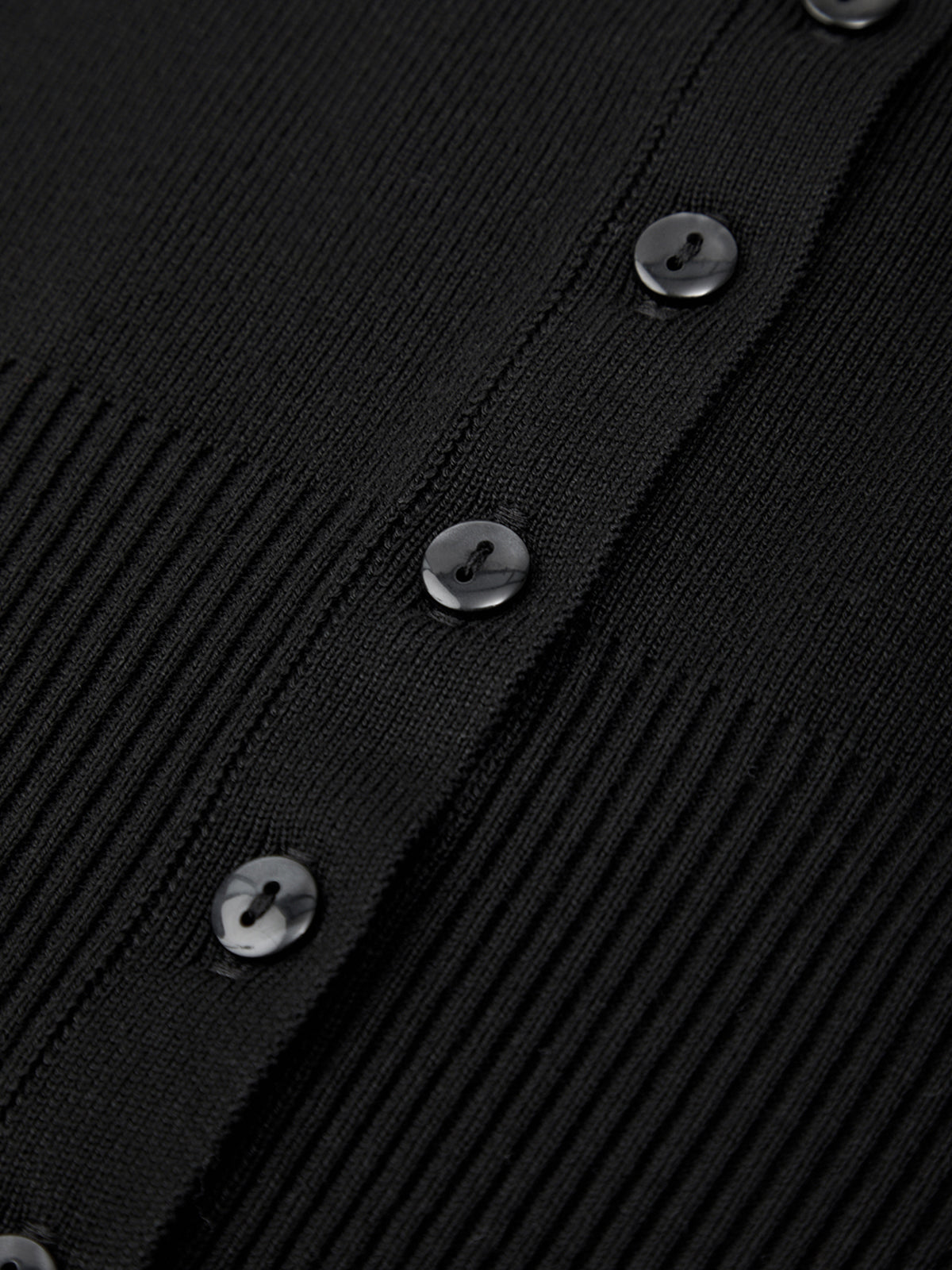 Close-up of a black textured fabric with buttons