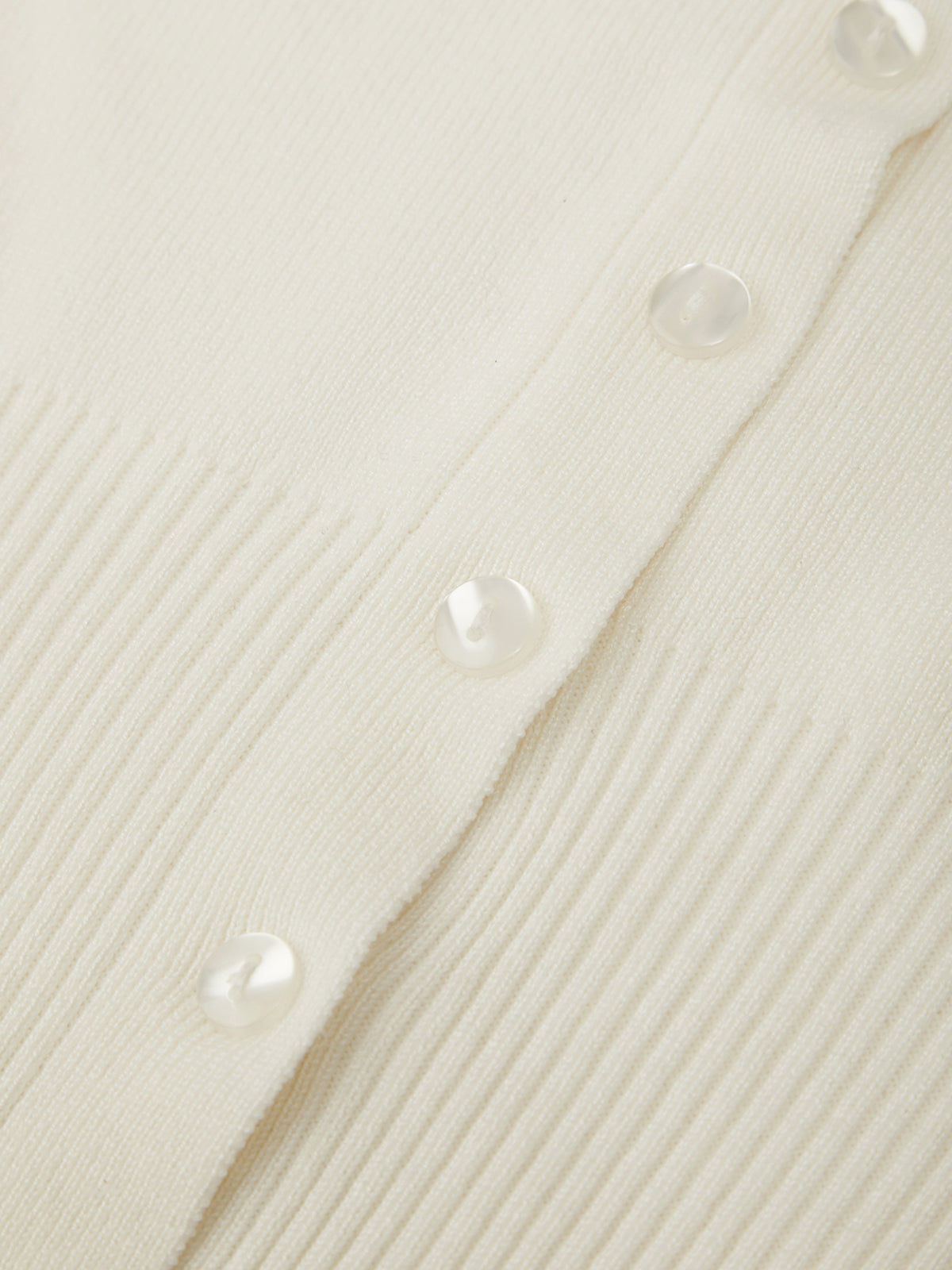 Close-up of a textured white fabric with buttons