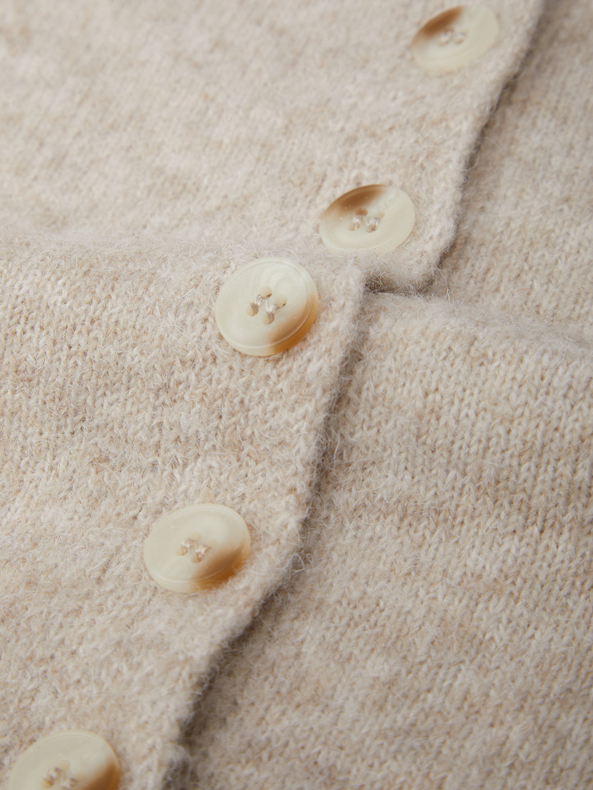 Close-up of beige fabric with buttons on a textured background