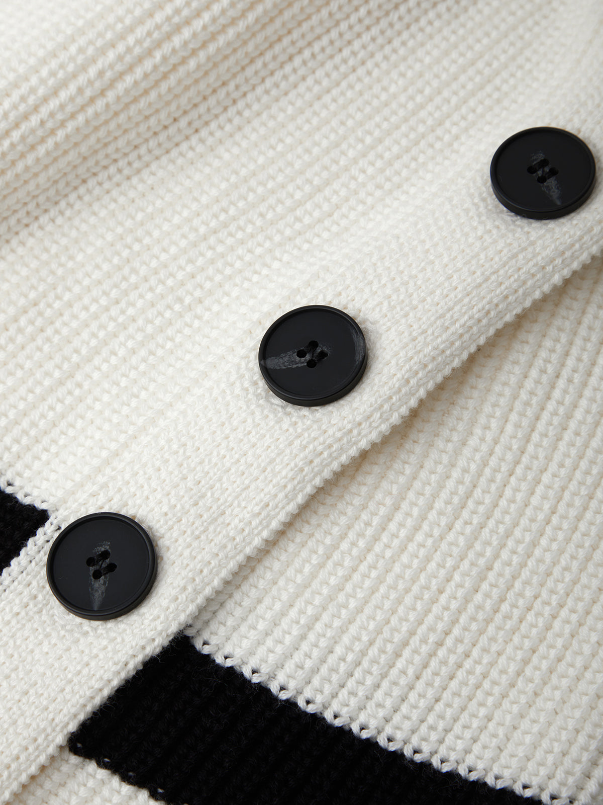 Close-up of a white textured fabric with black buttons