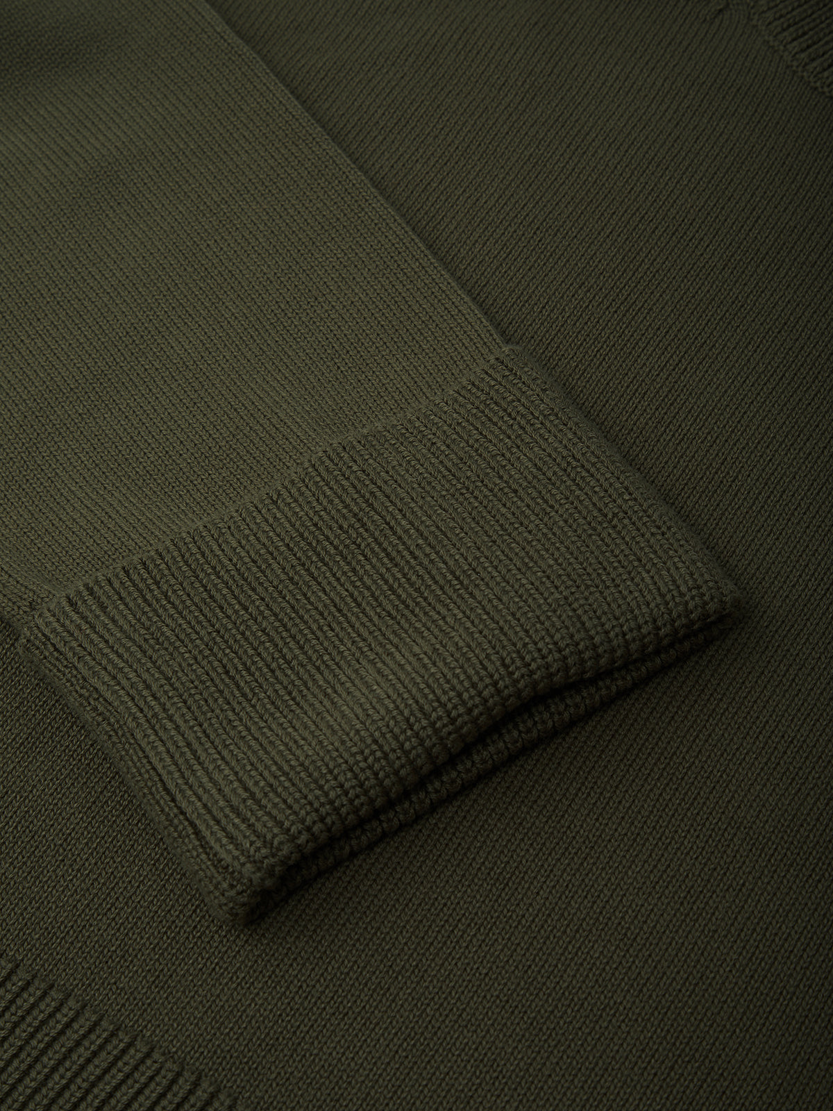 Dark green knitted sweater with a pattern on a dark background