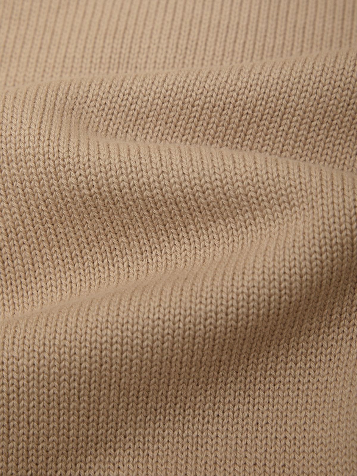 Close-up of beige knitted fabric texture