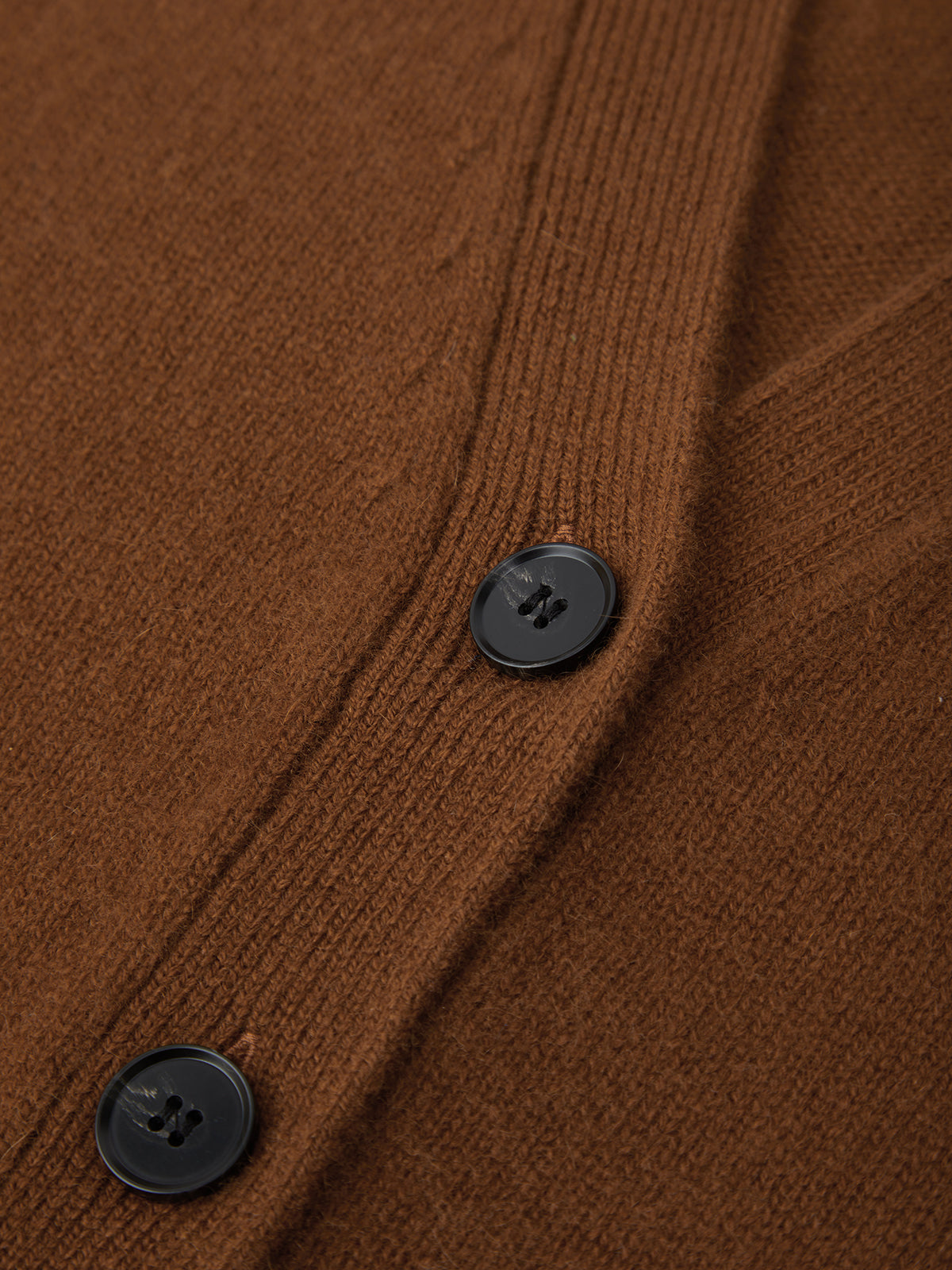 Close-up of a brown textured fabric with black buttons