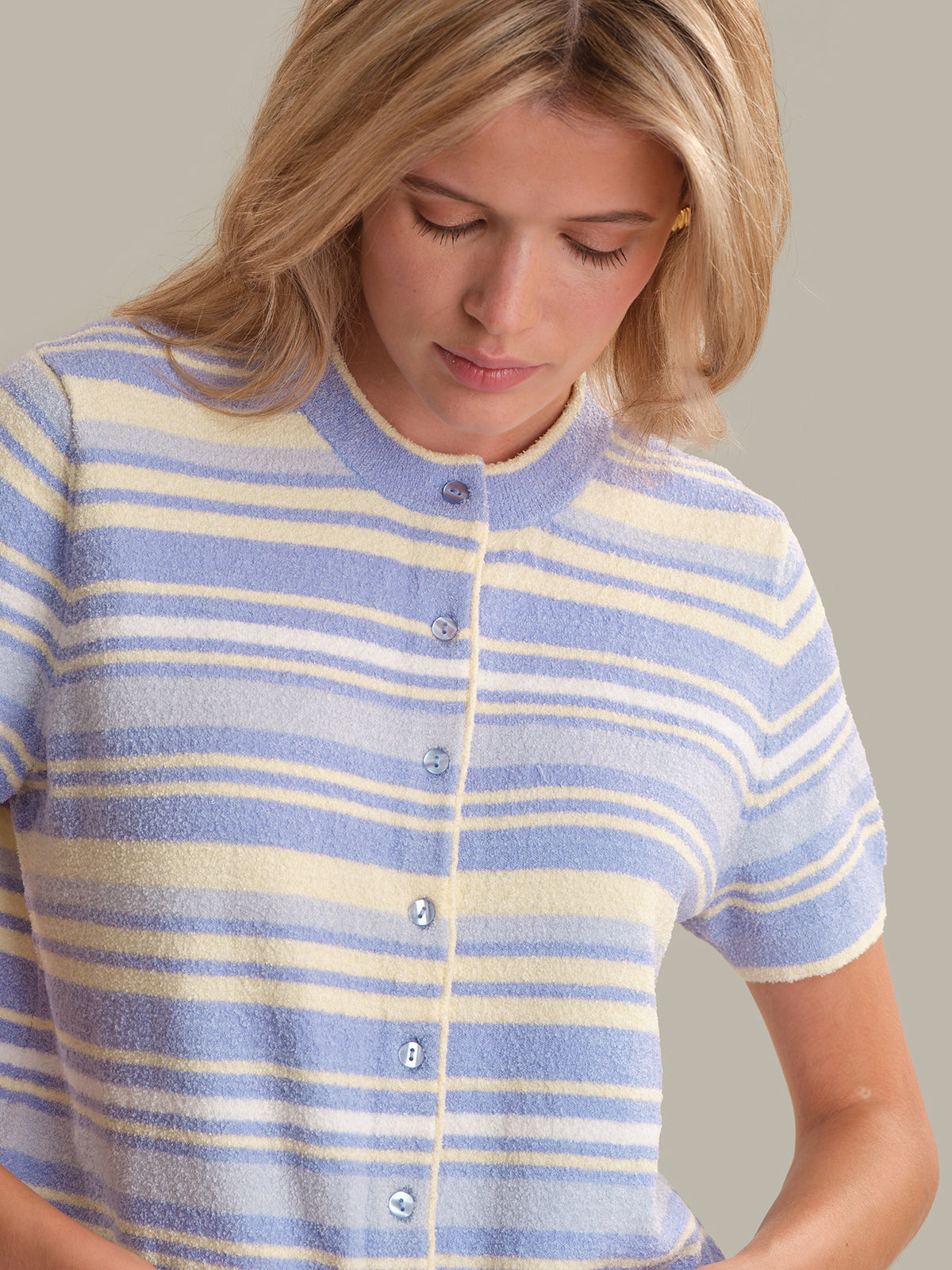 Woman wearing a blue and white striped shirt against a neutral background