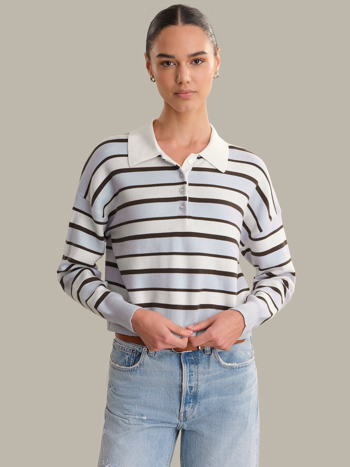 Woman wearing a striped long-sleeve shirt with a white collar against a plain background