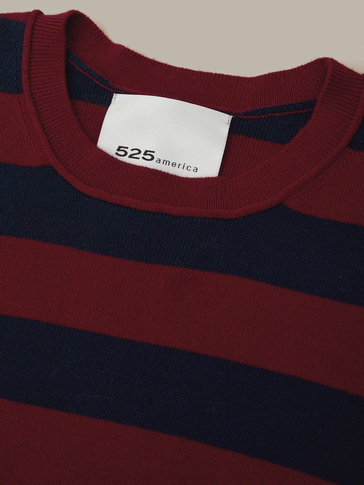 Close-up of a red and navy striped sweater with a visible brand label.