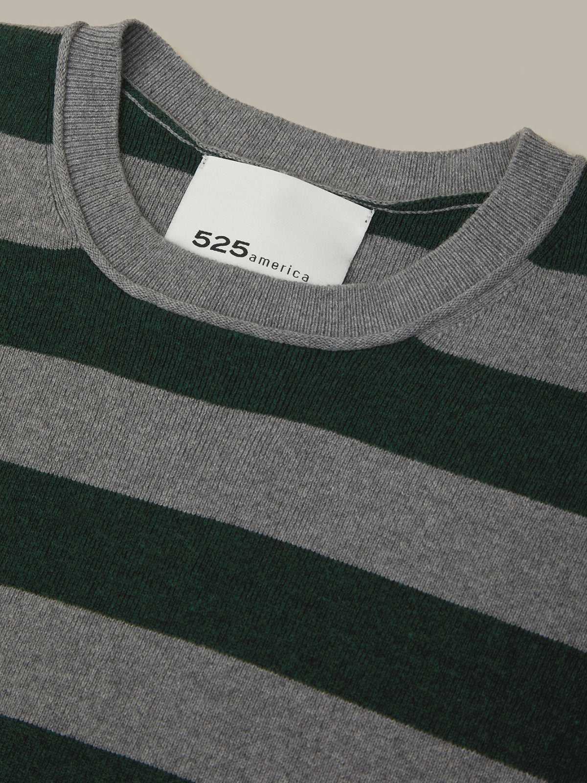 Close-up of a striped shirt with a visible brand label on a neutral background