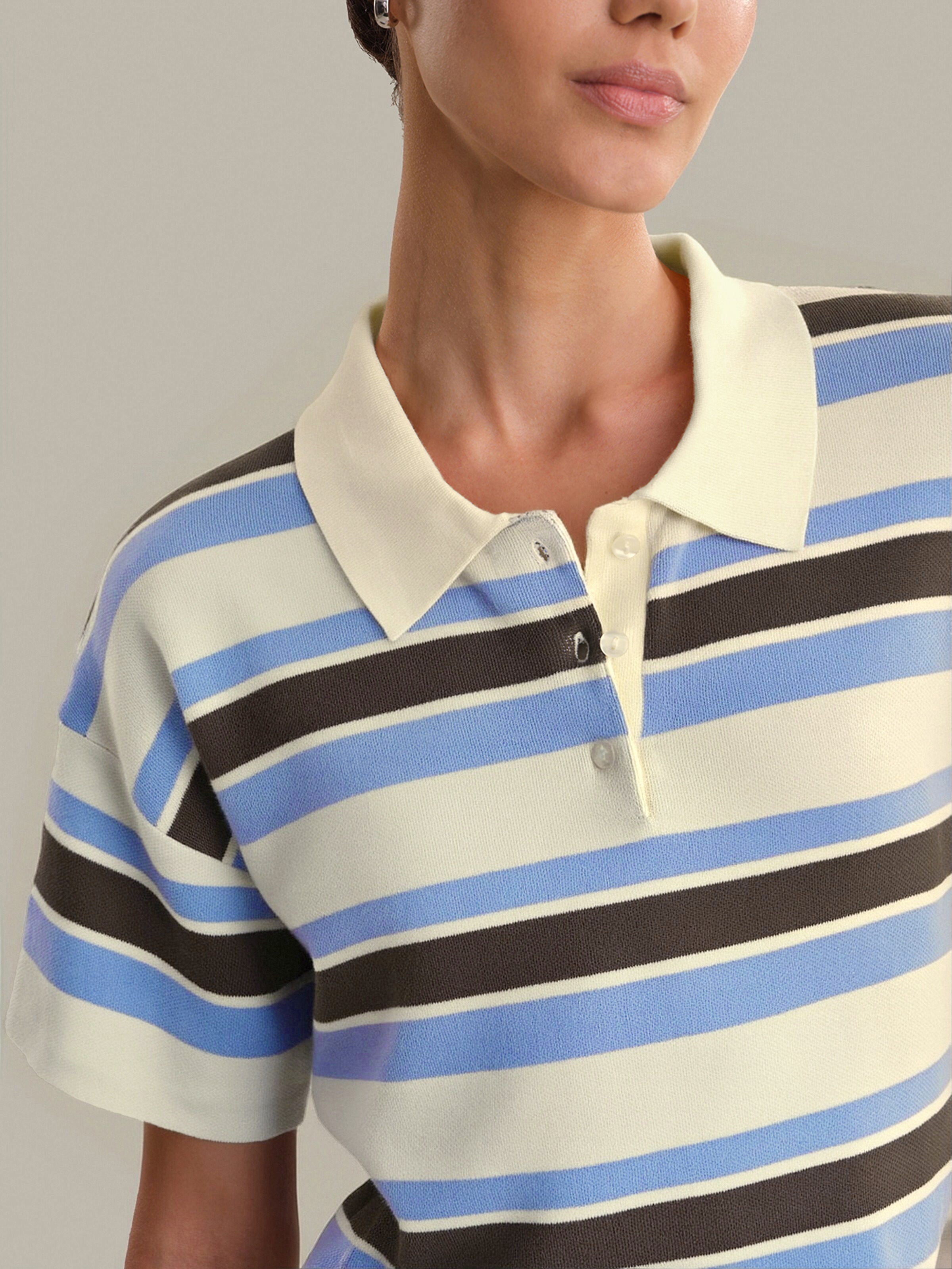 Person wearing a striped polo shirt with blue, black, and white horizontal stripes.