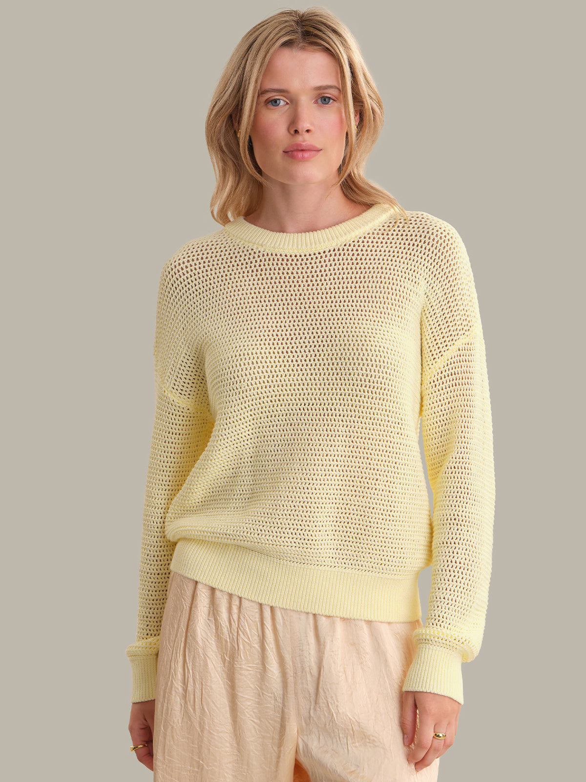 Woman wearing a light yellow sweater against a neutral background