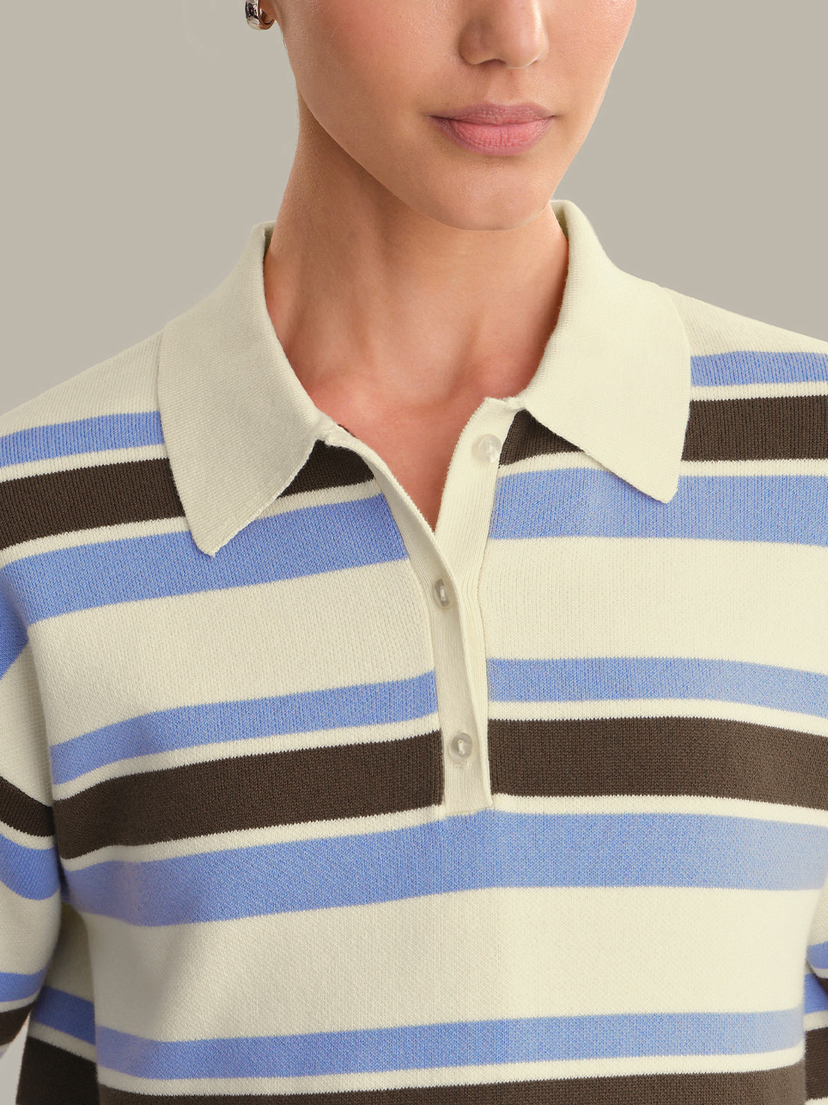 Close-up of a person wearing a striped polo shirt with blue, brown, and white horizontal stripes.