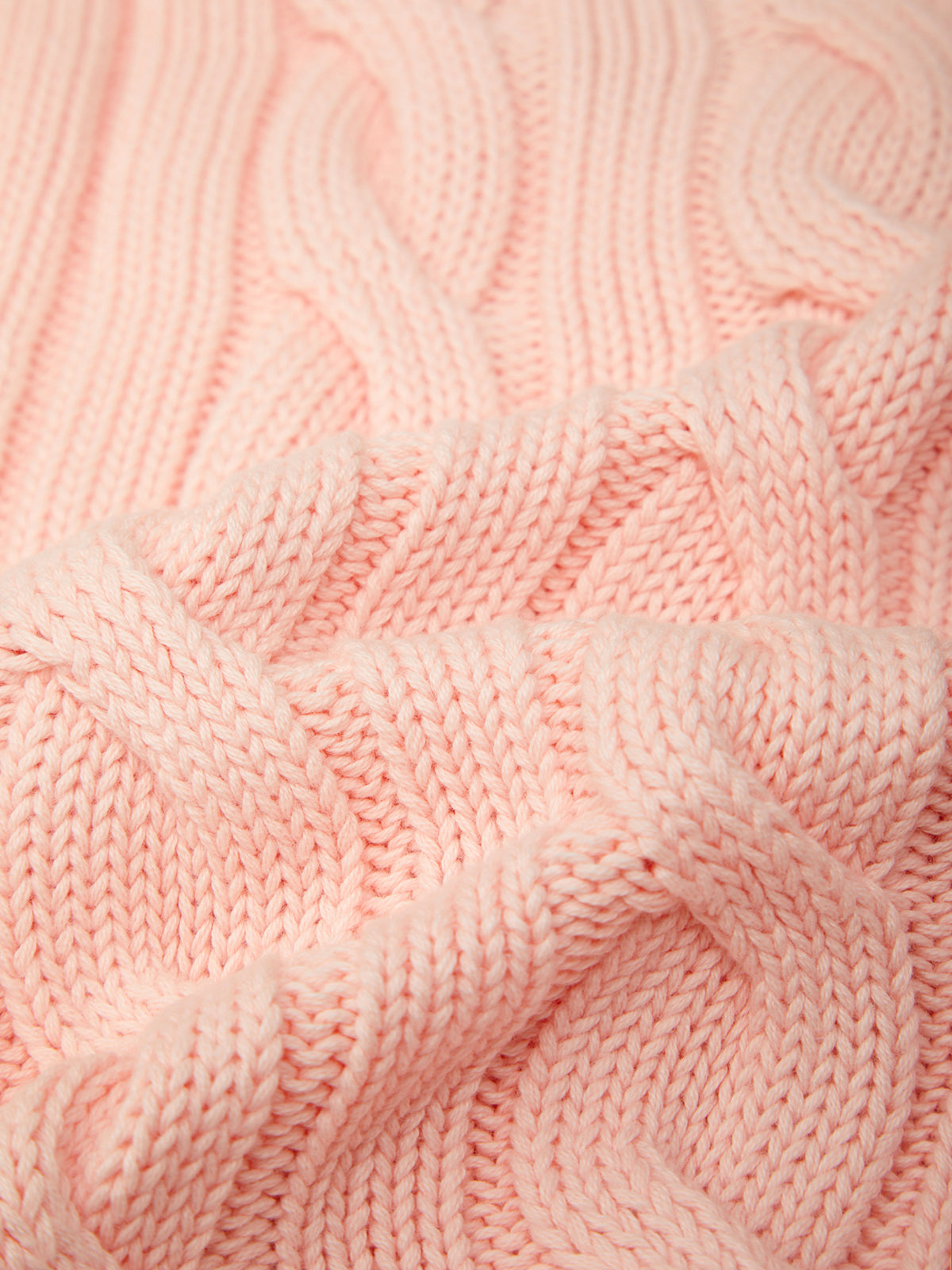 Close-up of pink knitted fabric with a textured pattern