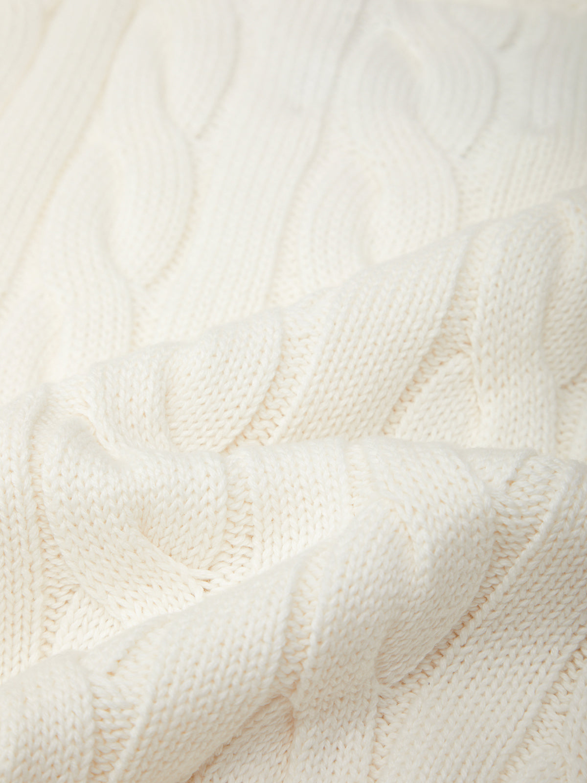 Close-up of a textured white fabric with a cable knit pattern