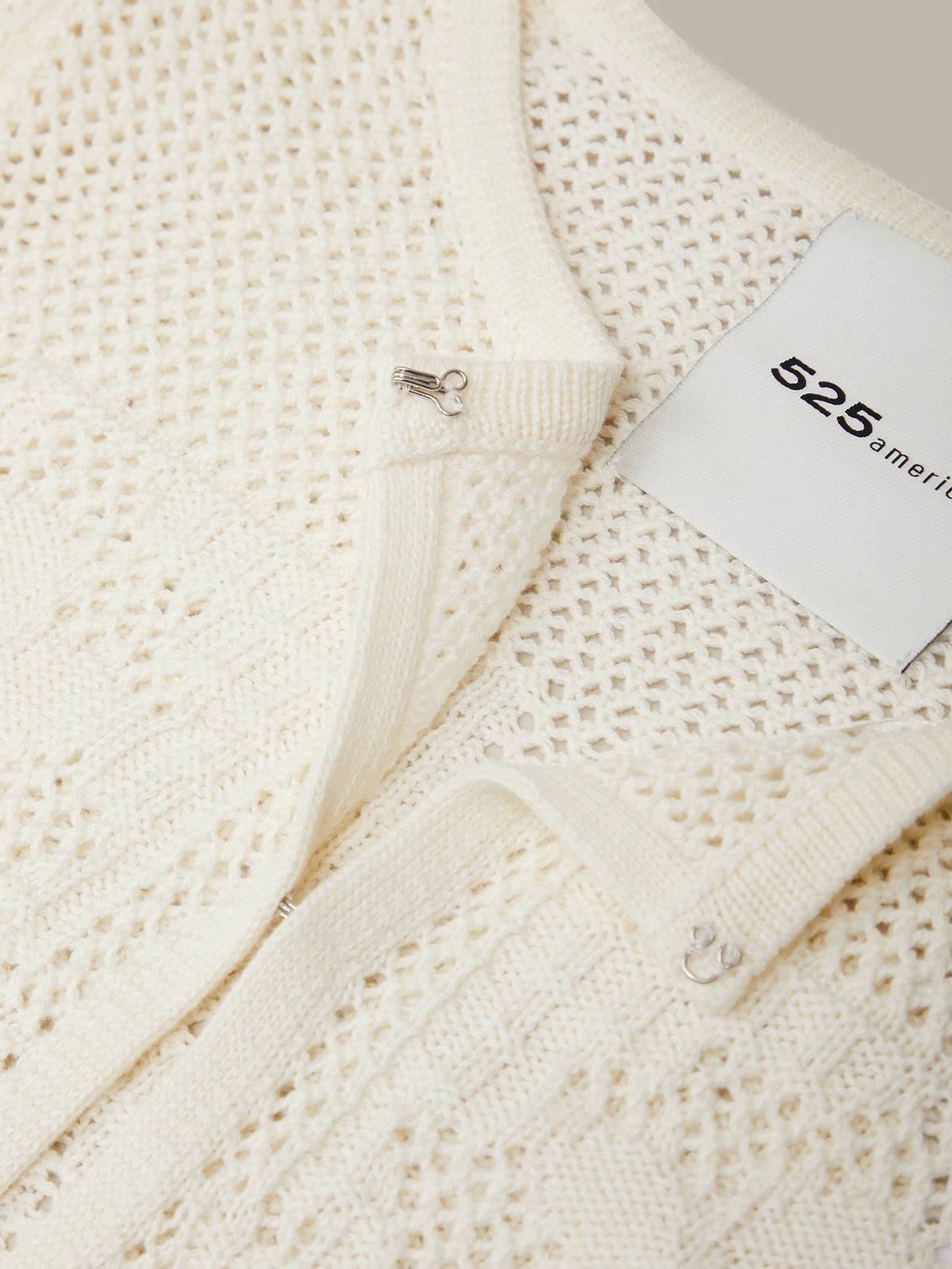 Close-up of a textured white fabric with a brand tag displaying '525 America'.