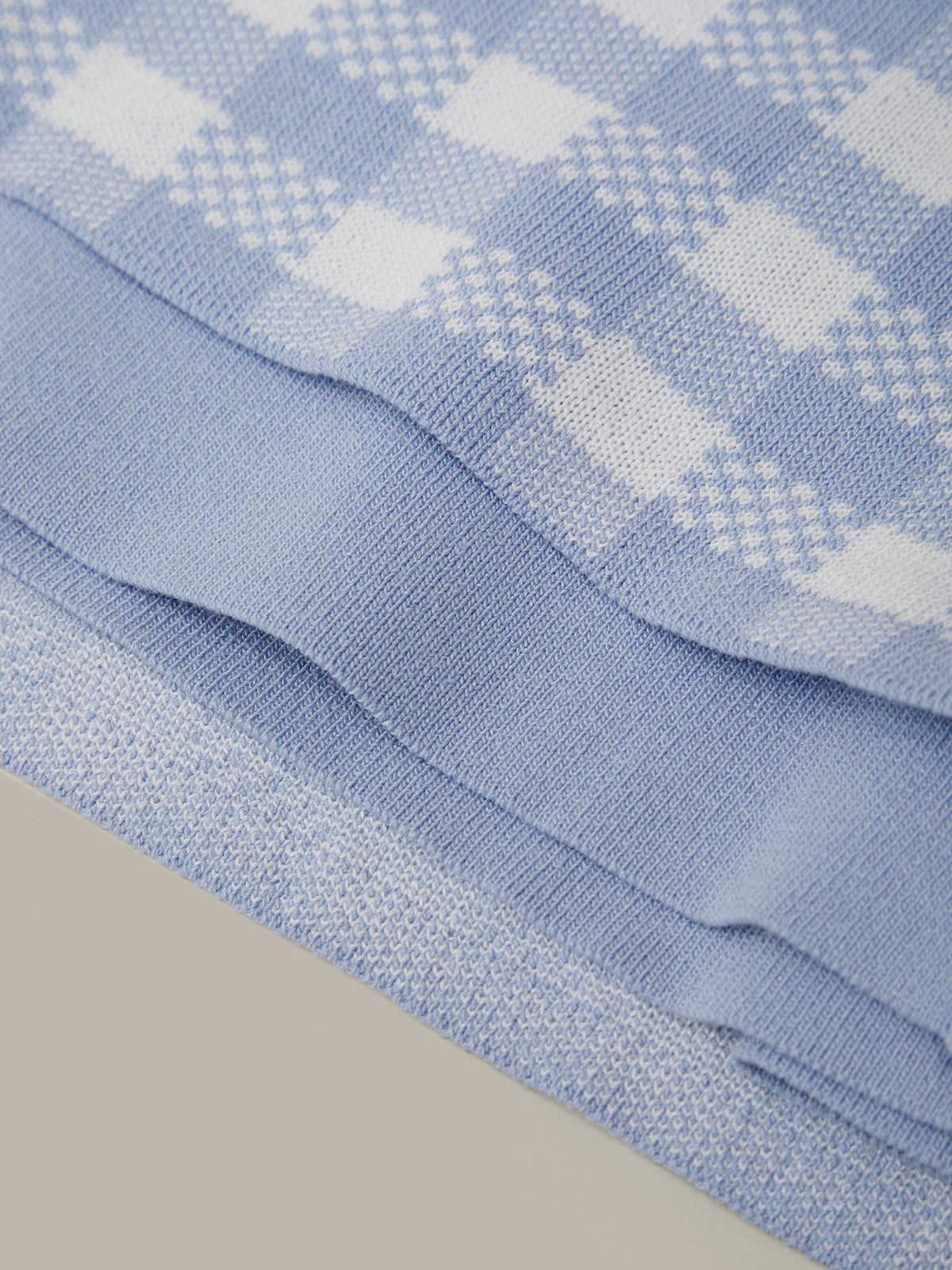 Stack of blue checkered fabric on a gray background