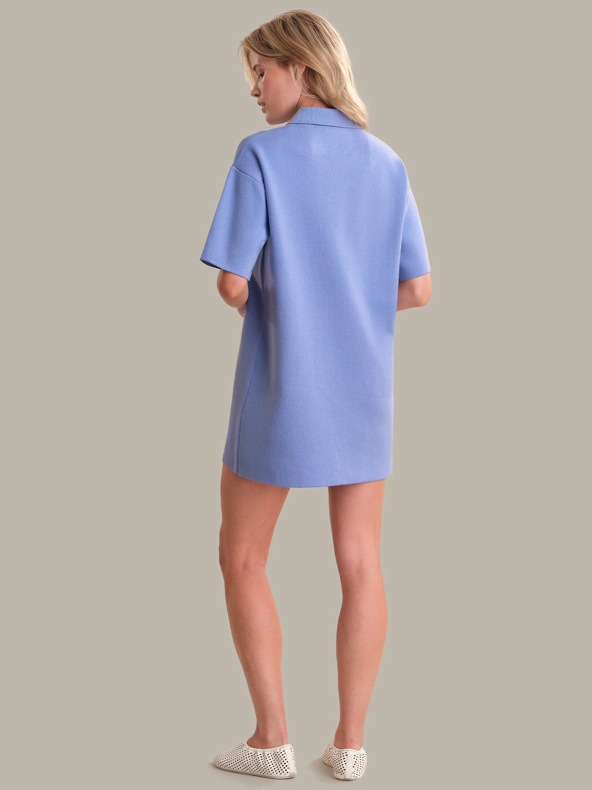 Woman wearing a light blue dress against a gray background