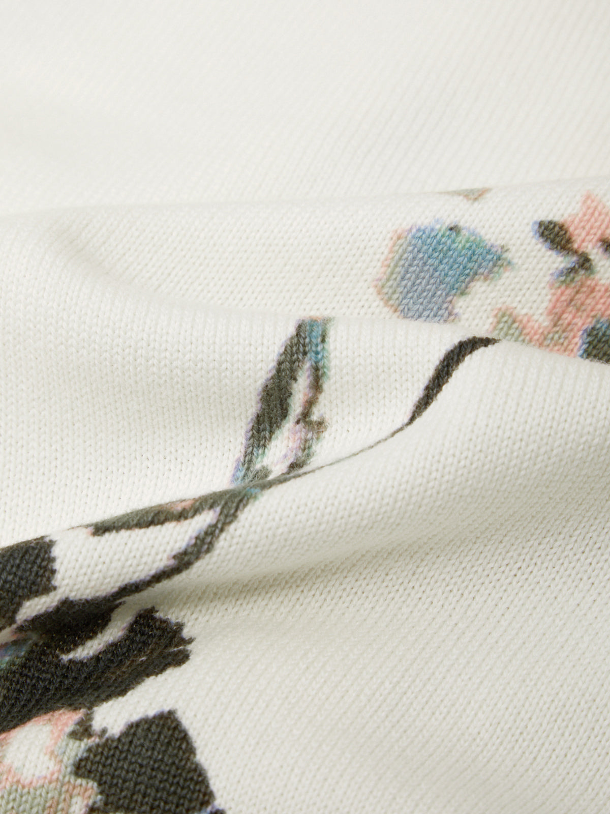 Close-up of a floral patterned fabric with black feathers on a white background