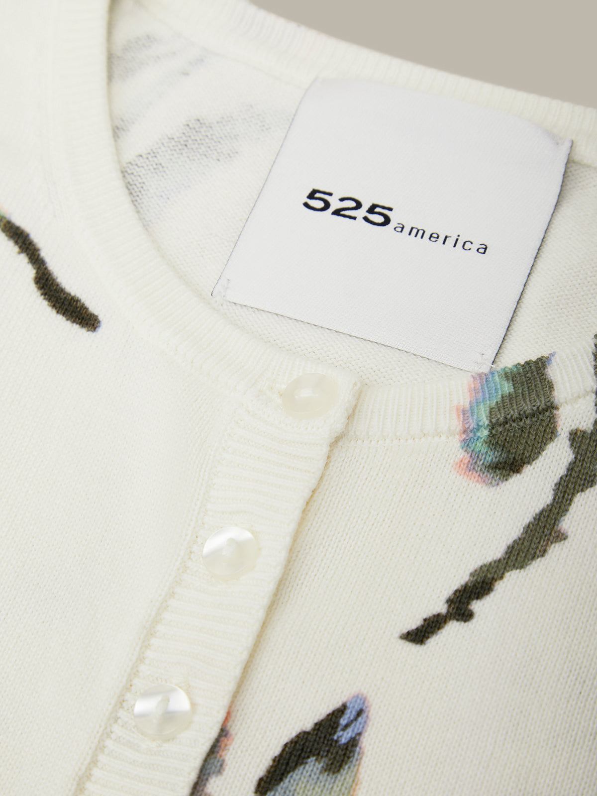 Close-up of a cardigan with a brand label displaying '525 america'.