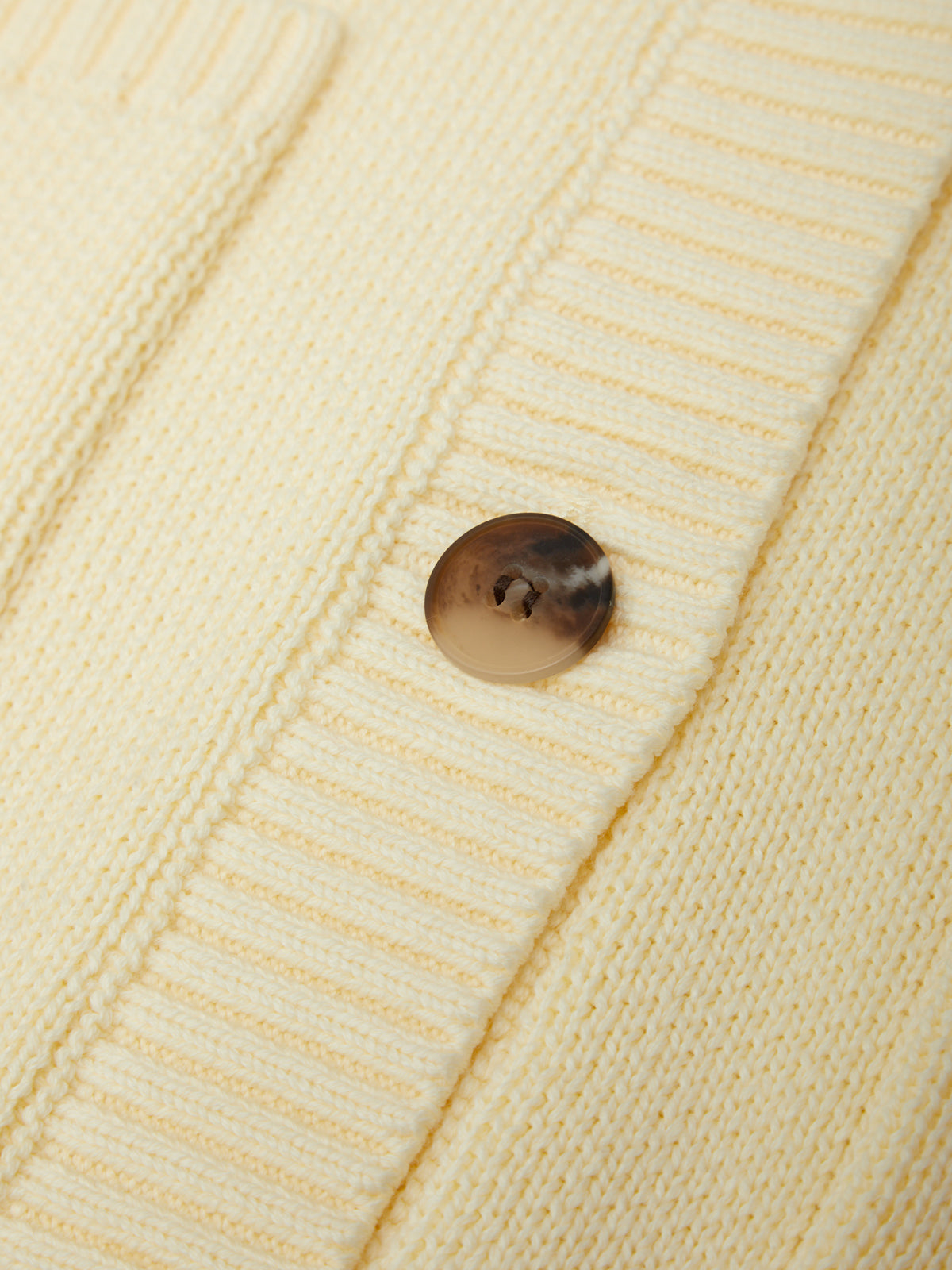 Close-up of a button on a beige textured fabric
