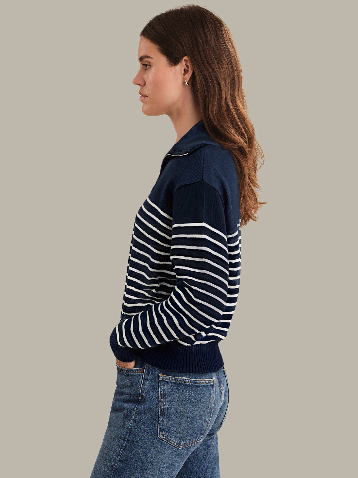 Woman wearing a navy and white striped sweater against a plain background
