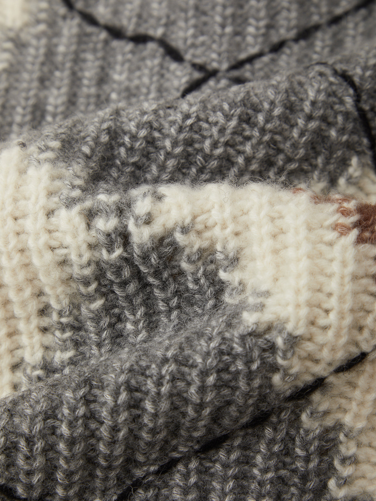 Close-up of a knitted fabric with gray and white pattern