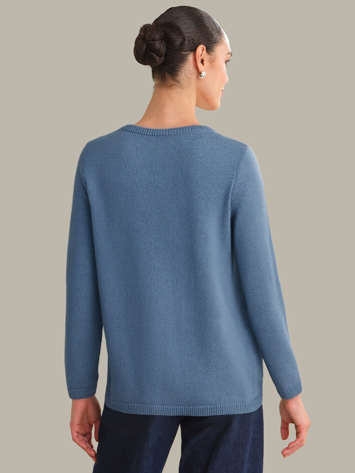Woman wearing a blue sweater against a gray background