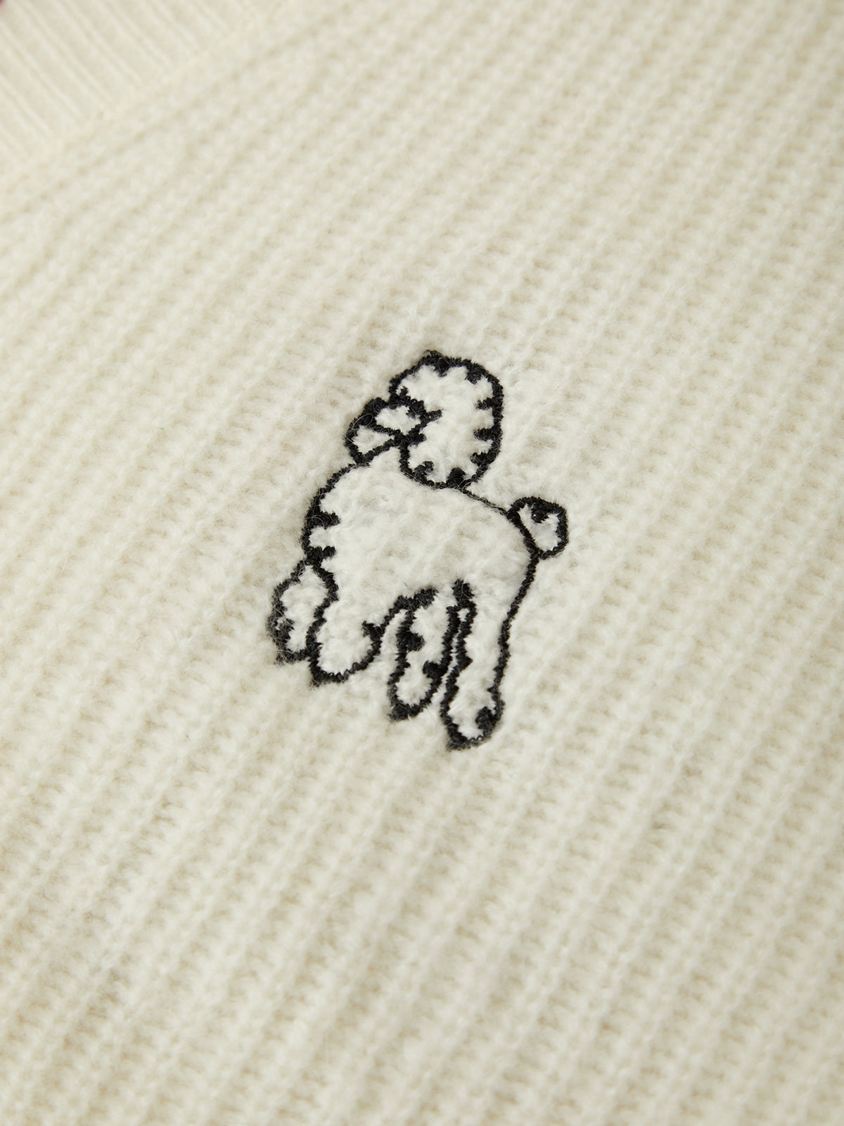 Embroidered poodle design on a textured beige fabric