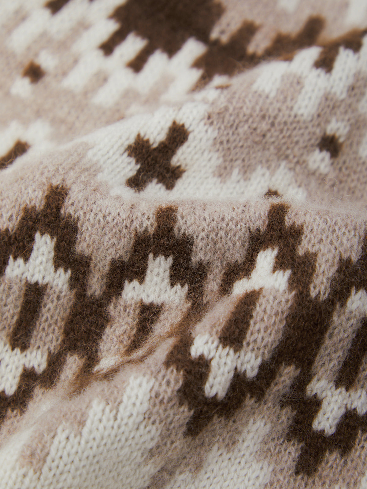 Close-up of a knitted fabric with a brown and beige pattern