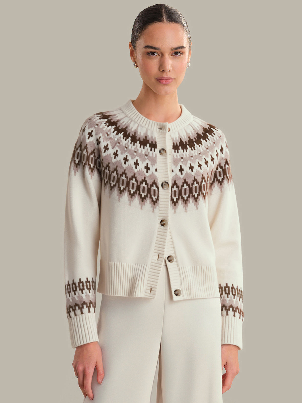 Woman wearing a patterned cardigan against a neutral background