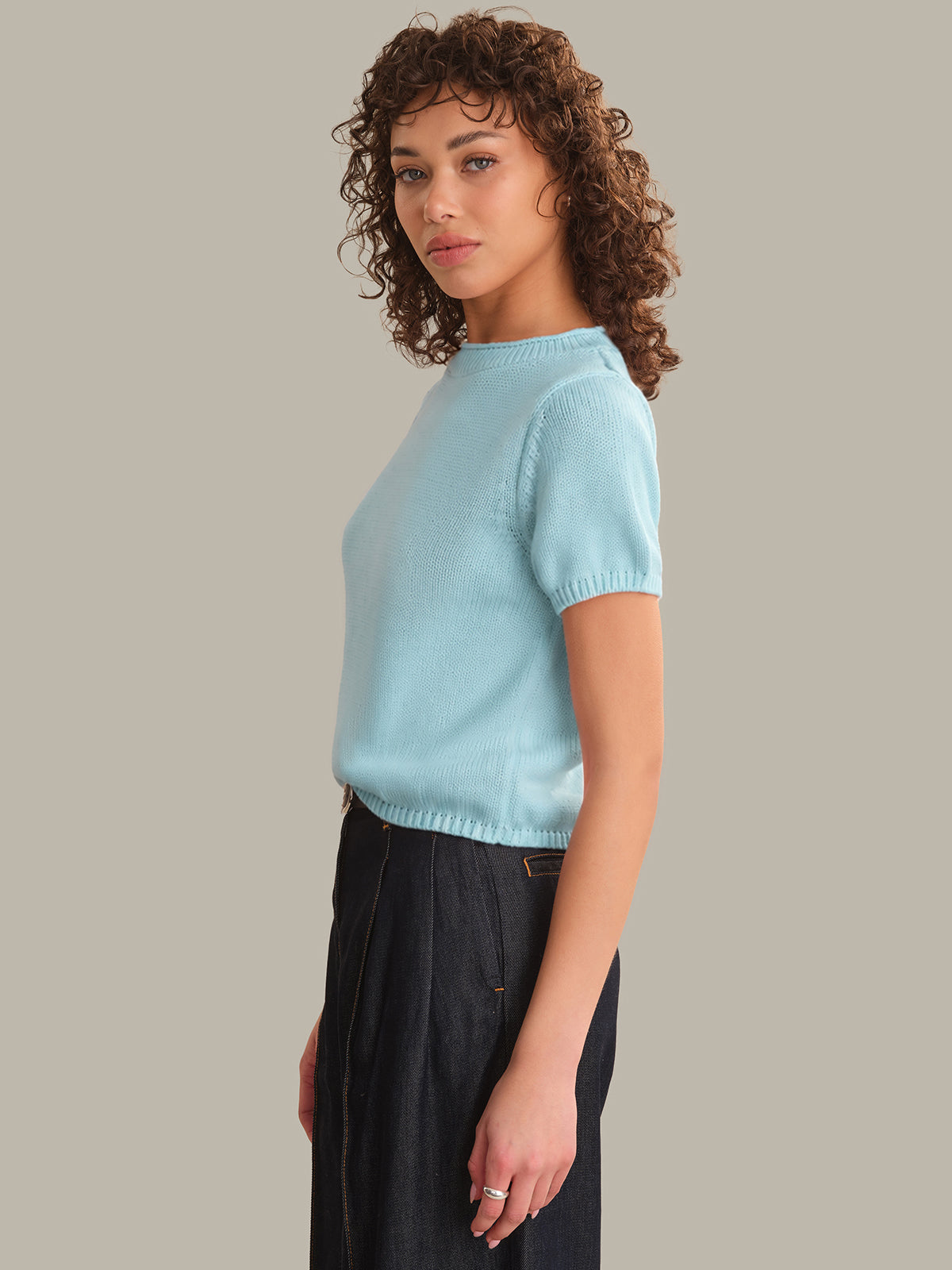 Woman wearing a light blue sweater against a plain background
