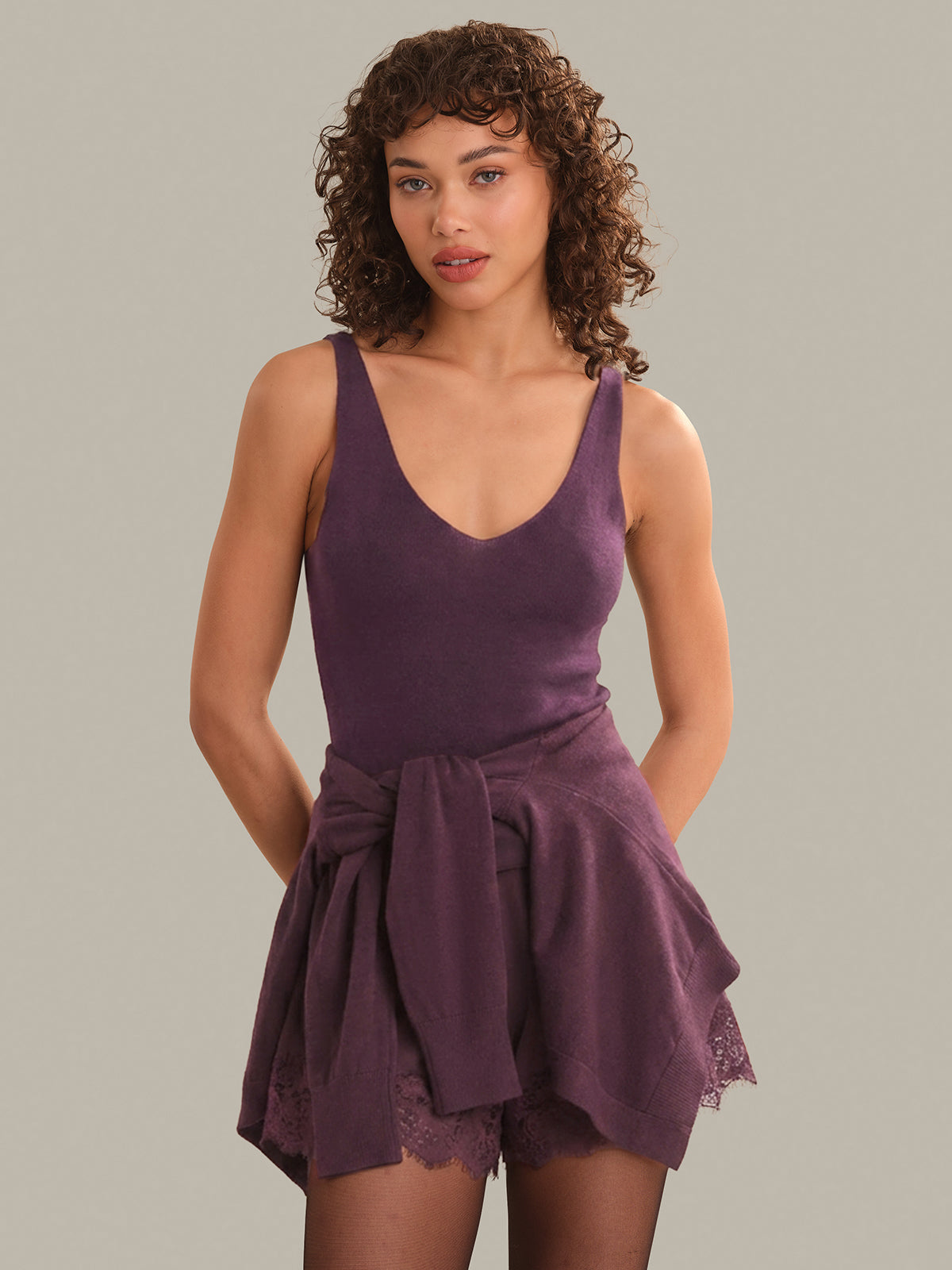 Woman wearing a purple tank with a plain background