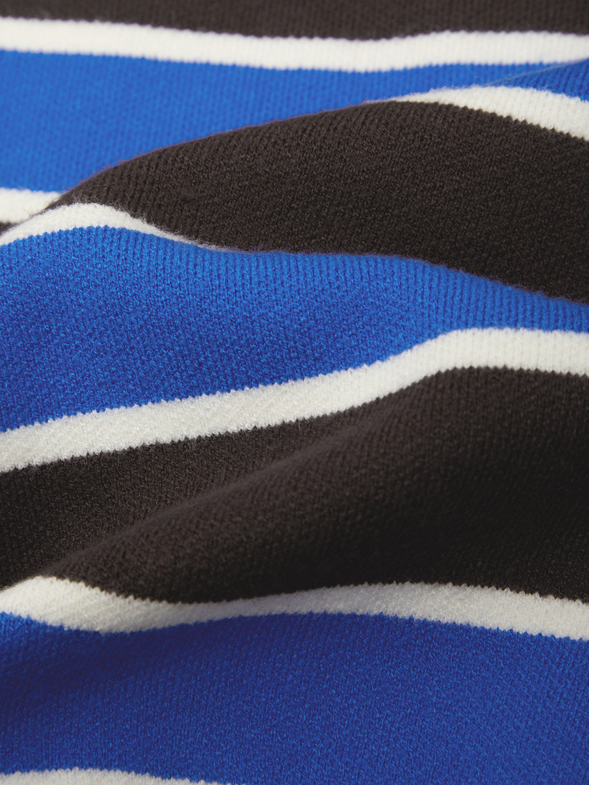 Close-up of a striped knit fabric with alternating bands of royal blue, dark brown, and white.
