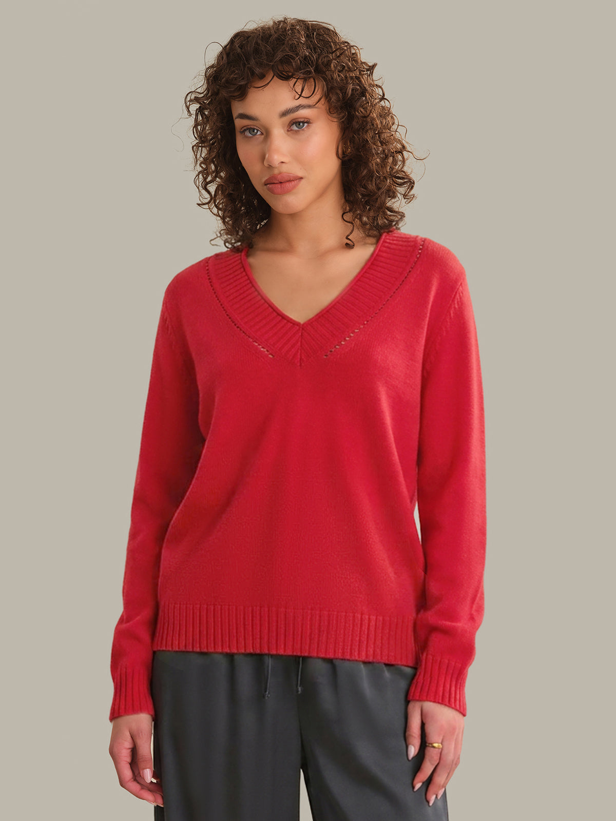 Woman wearing a red sweater against a neutral background