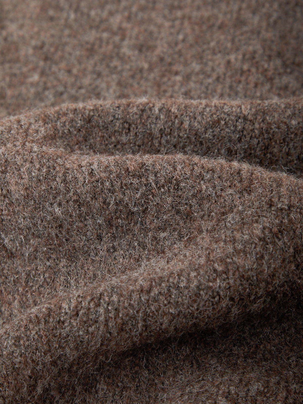 A close-up of a soft, textured fabric in a heathered brown and beige colorway, showing the fine knit or felted wool-like fibers and draped folds.
