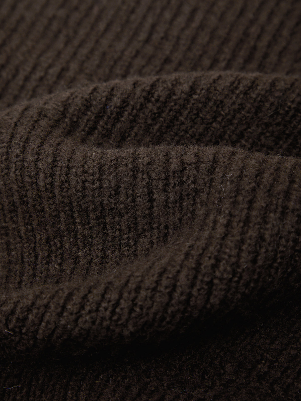 Close-up of a dark brown ribbed knit fabric texture with soft folds and a fine woven pattern.