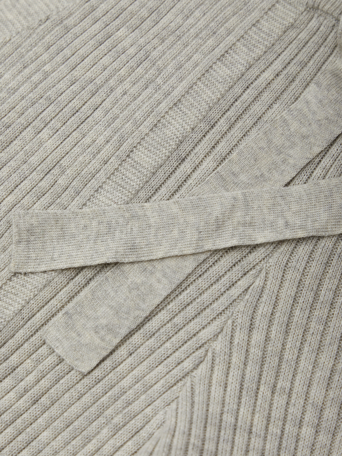 Close-up of a gray ribbed sweater with a focus on texture and pattern.