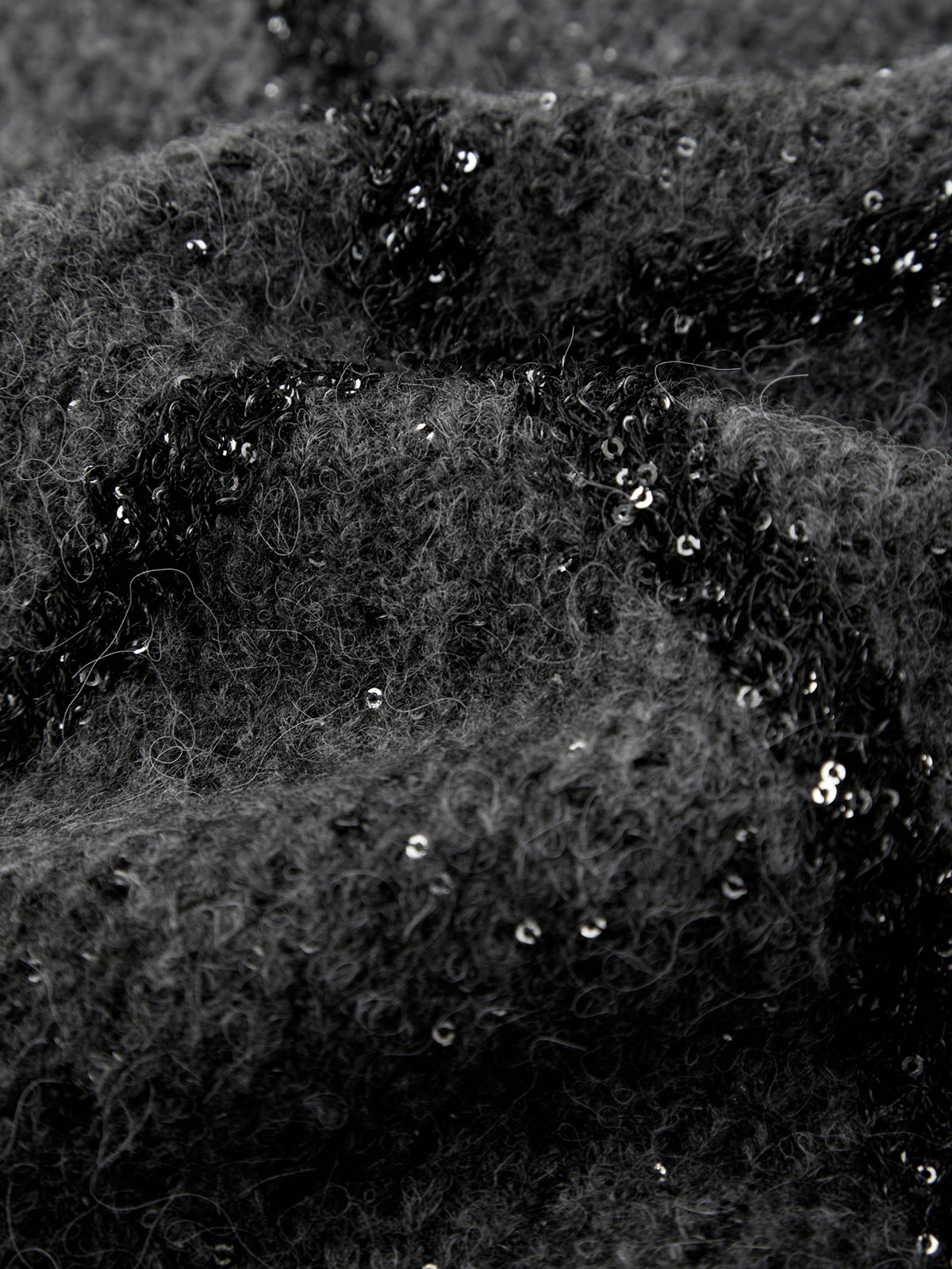 Close-up of black fabric with sequins on a dark background