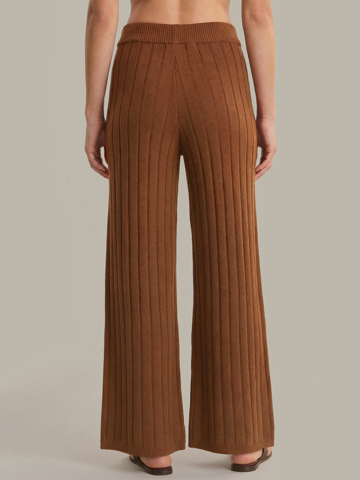Brown ribbed knit pants worn by a person on a neutral background