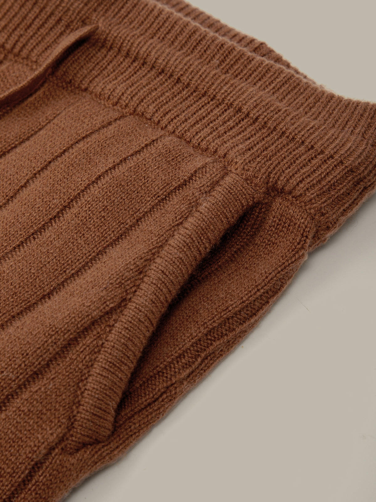 Brown ribbed sweater on a light gray background