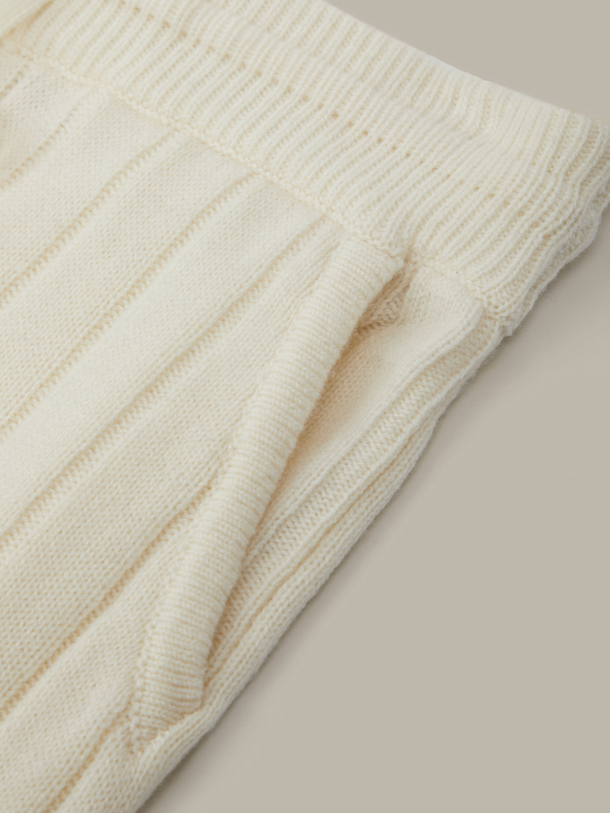 Close-up of a cream-colored knitted fabric on a beige background