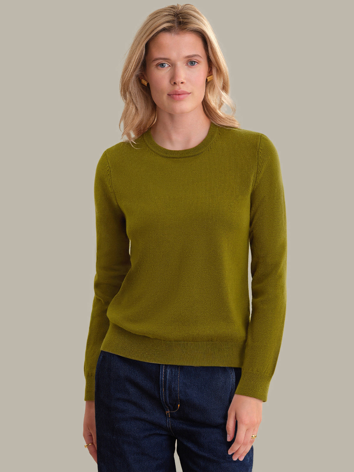 Woman wearing a green sweater against a plain background