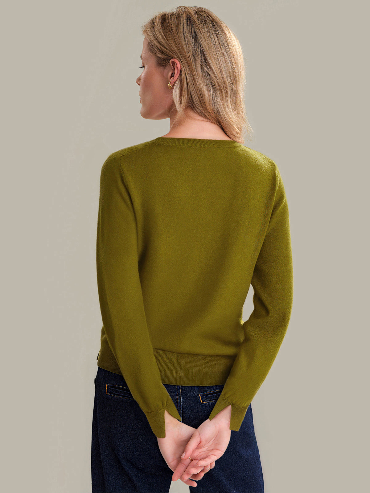 Woman wearing a green sweater against a plain background