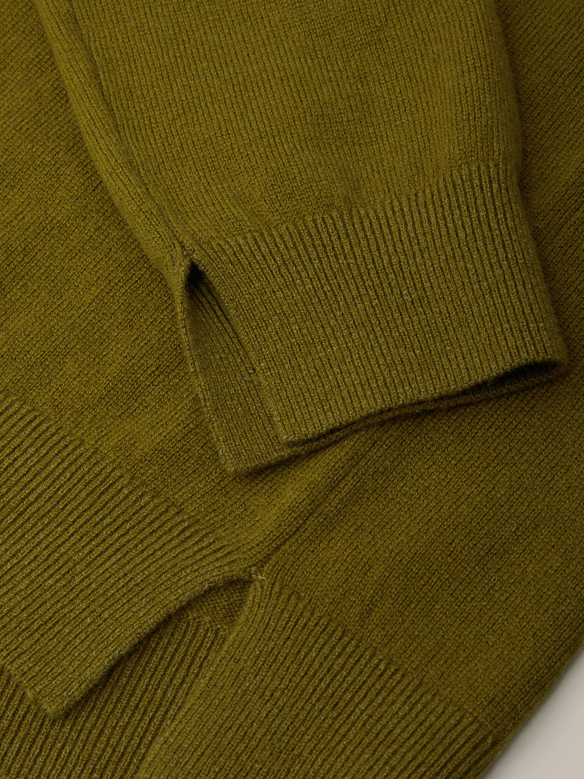 Close-up of a green knitted sweater on a white background