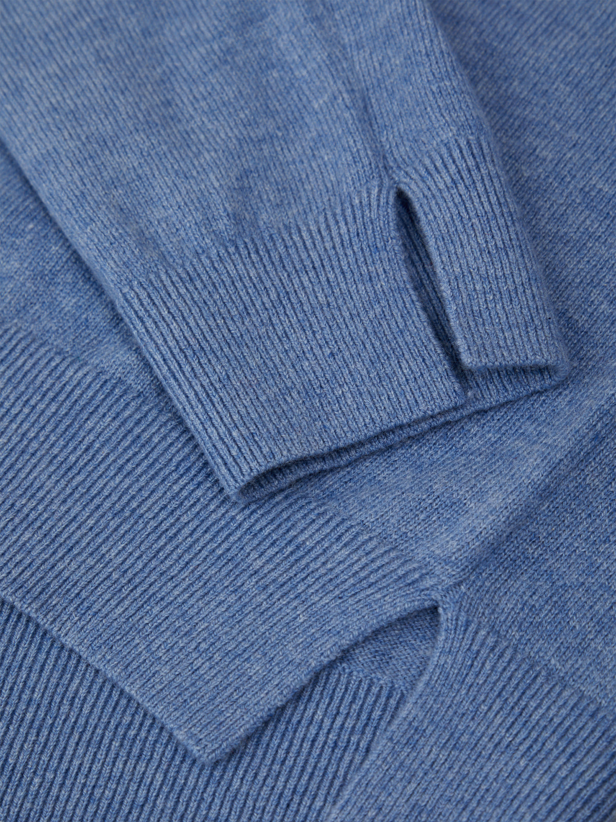 Close-up of a blue knitted sweater with a focus on texture and color.